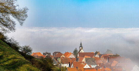 An ancient European town is shrouded in fog early in the morning
