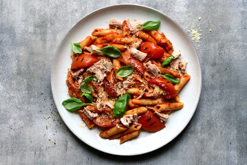 Penne pasta with grilled tomatoes and tuna. Top view with copy space.
