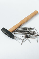 A hammer with nails lie on a white background. space for text