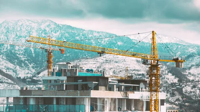 Machinery With Workers Are Engaged In Repairing Development On Construction Site. Development Of Modern Multi-storey Residential Houses. Workers Are Engaged In Development On Construction Site