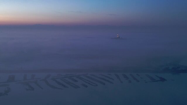 Grado lagoon above the fog. The city of Grado towards sunset.