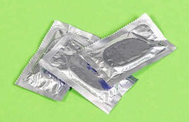 Condoms isolated on green - 760782751