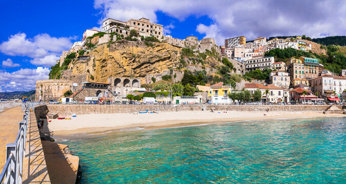 View from pier of Pizzo Calabro borgo with turquoise sea. Panoramic beach resort landscape in Calabria Italy with few people. Beautiful Mediterranean coastal town architecture on sunny summer day.