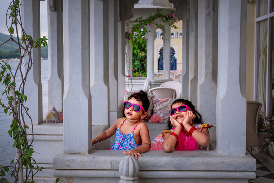 Beautiful Young Indian girls siblings dressed up in traditional Indian Rajasthani wear in a royal background 