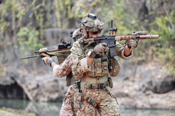 Soldiers  in camouflage military uniforms in shooting position ready for battle