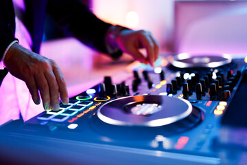 Hand eines Discjockeys an einem Mischpult