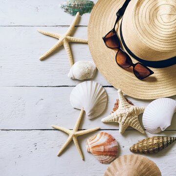 Summer beach dress items - shells, starfish, sunglasses, straw hats on a white background For pictures, travel, holidays and travel