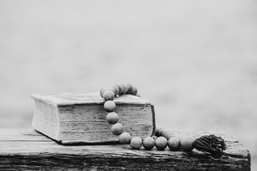 An old book and wooden rosary lie on benches in parks in Ukraine, faith and religion
