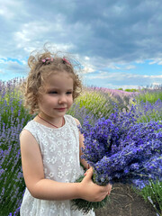 Little girl in white dress with lavender bouquet