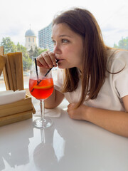 Cute woman drinking red cocktail