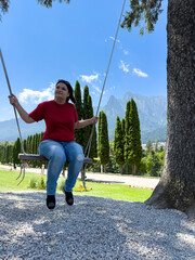 Woman riding on a swing near the mountains