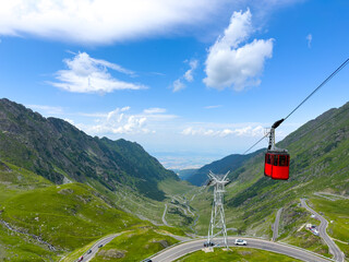 A red carriage descends by cable car in the mountains