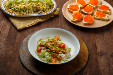 Thai chicken with rice in sauce, canap s with caviar and salad with ivy on a table