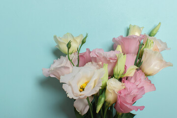 A bouquet of pink and white flowers of eustoma, lisianthus on a light blue background with a place for text. a place to copy