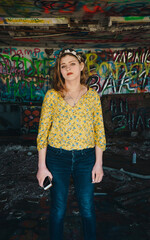 woman in yellow shirt standing in graffiti building
