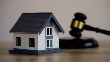 House model, hammer judge gavel on wooden table with white wall background. Foreclosure, bankruptcy concept. Person is unable to repay outstanding debts or obligations, stops mortgage payment. - obrazy, fototapety, plakaty