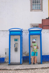 Bright blue phone cabin being used by a tourist in the mediterranean