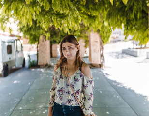 woman standing in walkway with vine covered overhang