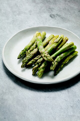 Raw wild asparagus on a plate seen from above