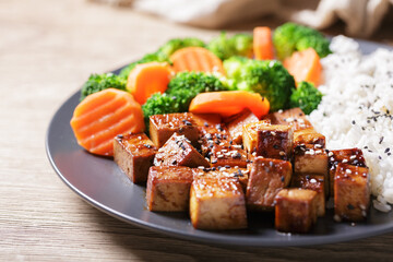 close up of plate of fried tofu, rice and vegetables with sesame seeds - 760815376
