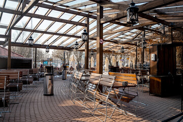 A restaurant with an outdoor terrace on the street with wooden furniture, the restaurant has not...