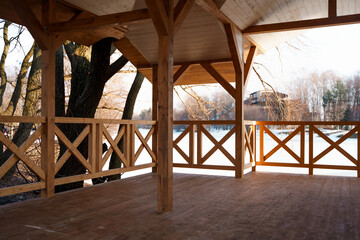 Fototapeta na wymiar Wooden gazebo with a fence in the park in spring