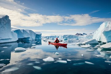 Panoramic view of an ecologist tourist in an inflatable boat. A researcher in a red kayak against a background of glaciers and an iceberg in Antarctica. Study of global warming at the north pole