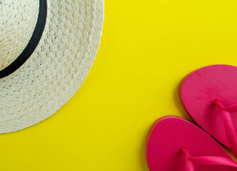 Flatlay, summer vacation. Hat and sandals on a yellow background.