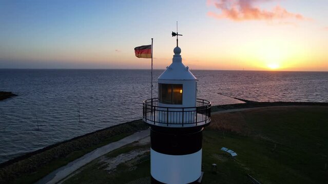 Lighthouse in the sunset - Wremen - Little Prussia lighthouse - circling flight Aerial view in the sunset over the sea