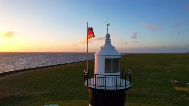 Lighthouse in the sunset - Wremen - Little Prussian lighthouse - aerial view circling to the right on the Kupper of the lighthouse in the sunset in a stormy wind