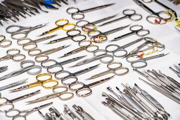 Set of many different scissors for manicure. Metal scissors on a white background. Close-up