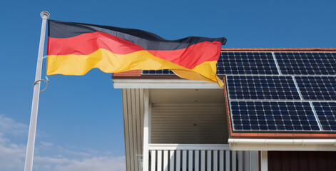 German flag flutters on the background of roof with solar panels.