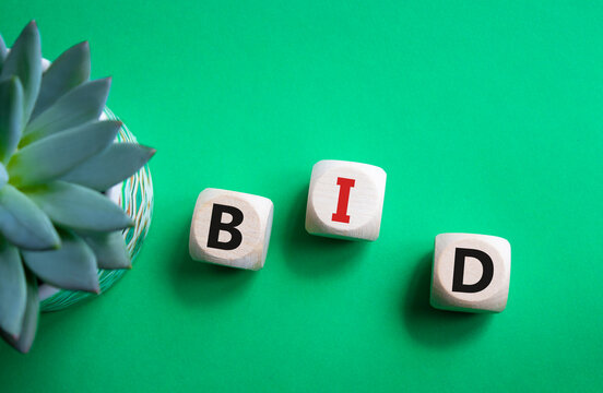 BID symbol. Concept word BID on wooden blocks. Beautiful green background with succulent plant. Business and BID concept. Copy space