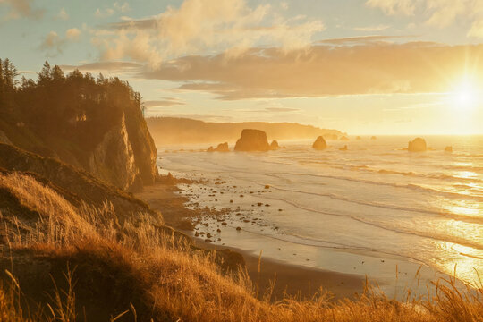 Wild and rugged coastal landscape with crashing waves during sunset