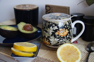 Healthy snack - mug of tea, lemon and avocado