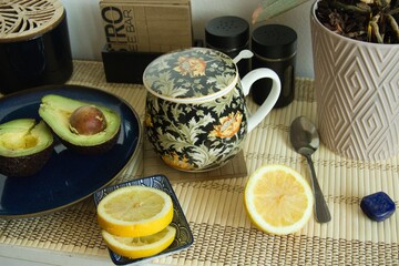 Healthy snack - mug of tea, lemon and avocado