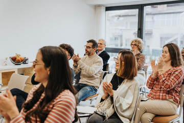 Group of business employees applauding after successful business training at modern, small...