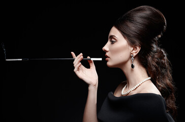 Retro shot: beautiful young woman smoking cigarette. Vintage portrait of pretty girl in 60s style....