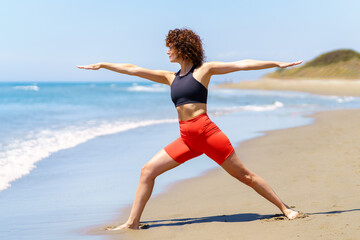 Fit woman doing yoga on beach