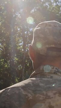 Back view of male soldier leaving on military service. Man in military uniform. Ukrainian Armed Forces. Concept of military service, army, duty. Vertical video