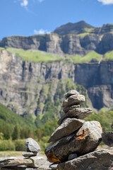 Stack of balancing rocks symbolising peace and mindfulness over a lush mountain landscape