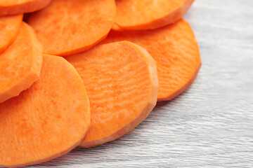 Sliced raw sweet potato tuber on a kitchen board. Nutritious ingredients