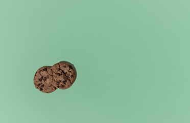 Cookies with chocolate pieces on a colored background. Flat lay, space for text.