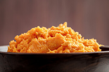 Hot mashed sweet potatoes with steam in wooden bowl. Healthy vegetable puree