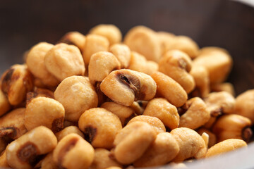 Organic salty roasted dried maize grains in wooden bowl. Tasty beer snack of fried corns