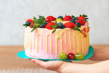 Festive delicious sponge cake covered with icing and berries