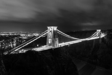 Black and white Clifton Suspension Bridge at night with light trails