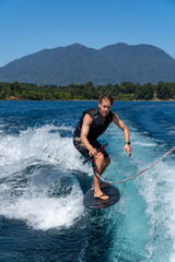 young man doing wake surf in a summer day in the lake.