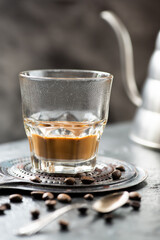 Vietnamese coffee with milk in a glass, silver spoon, coffee beans on a dark background - 760856128