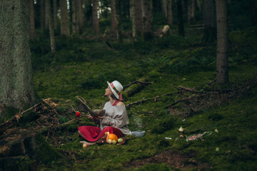 Woman shaman performs a ritual in the forest